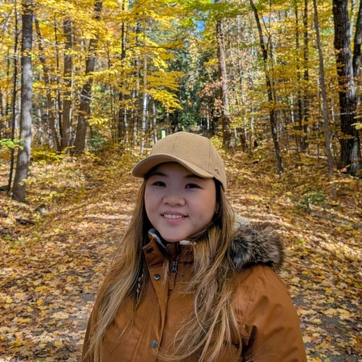 Samantha Fung smiling on an autumn forest trail